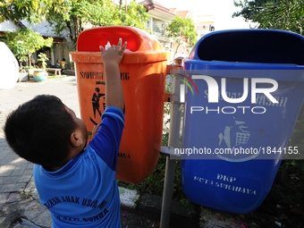 A boy throws the garbage into trash can.
Surabaya Municipality Government has developed an effective community education program about waste...