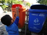 A boy throws the garbage into trash can.
Surabaya Municipality Government has developed an effective community education program about waste...