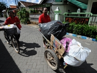 Two women push cart contain of garbage to Bank Sampah. 
Bank Sampah (Garbage Bank) is a small business unit in neighborhood community operat...