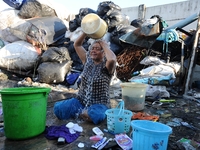 Nurtinah baths after work as a scavenger.
Nurtinah, 47, a farm worker from Pucang Anom village, Cerme sub-district, Bondowoso district, East...