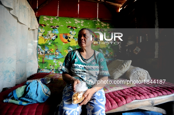 Nurtinah takes a break after working as a scavenger in her small hut.
Nurtinah, 47, a farm worker from Pucang Anom village, Cerme sub-distri...