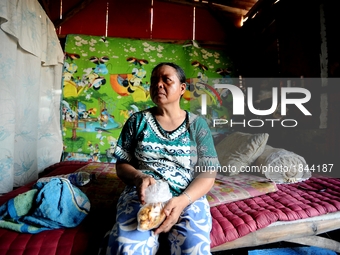 Nurtinah takes a break after working as a scavenger in her small hut.
Nurtinah, 47, a farm worker from Pucang Anom village, Cerme sub-distri...