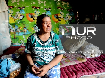 Nurtinah takes a break after working as a scavenger in her small hut.
Nurtinah, 47, a farm worker from Pucang Anom village, Cerme sub-distri...