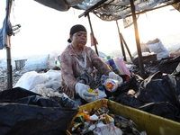 Nurtinah sorts the garbage.
Nurtinah, 47, a farm worker from Pucang Anom village, Cerme sub-district, Bondowoso district, East Java Province...