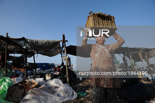 Nurtinah lifts the garbage to sort.
Nurtinah, 47, a farm worker from Pucang Anom village, Cerme sub-district, Bondowoso district, East Java...