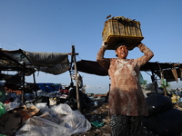 Nurtinah lifts the garbage to sort.
Nurtinah, 47, a farm worker from Pucang Anom village, Cerme sub-district, Bondowoso district, East Java...