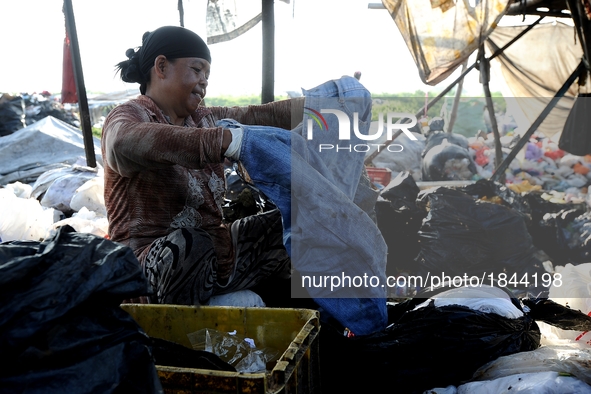 Nurtinah separates clothes from the recycled garbage.
Nurtinah, 47, a farm worker from Pucang Anom village, Cerme sub-district, Bondowoso di...