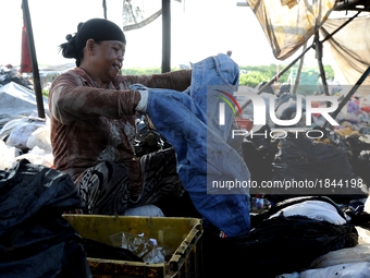 Nurtinah separates clothes from the recycled garbage.
Nurtinah, 47, a farm worker from Pucang Anom village, Cerme sub-district, Bondowoso di...