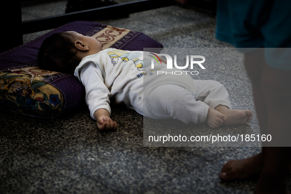 A child sleeping on the floor of a make-shift refugee camp in Jabalya, Gaza on July 18th, 2014. The former school currently holds approximat...