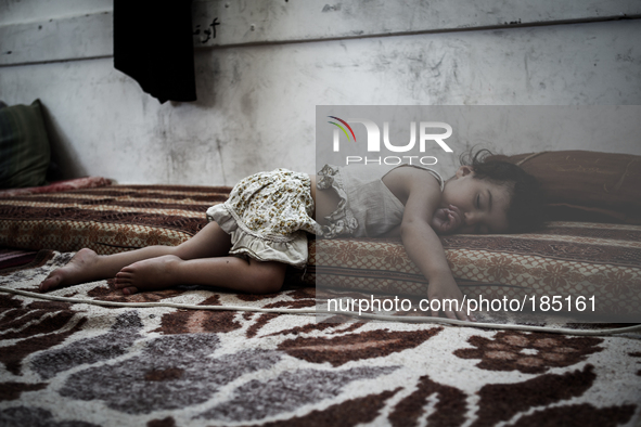 A young girl sleeping in a make-shift refugee camp in Jabalya, Gaza on July 18th, 2014. The former school currently holds approximately 3500...