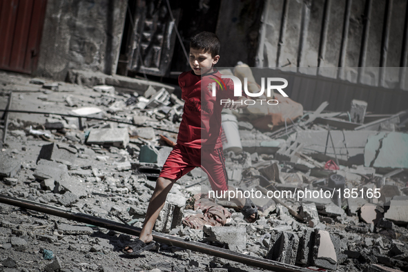 A young boy runs through the remains of a home on Jaffa Street in Northern Gaza City minutes after the house was attacked by an Israeli F-16...