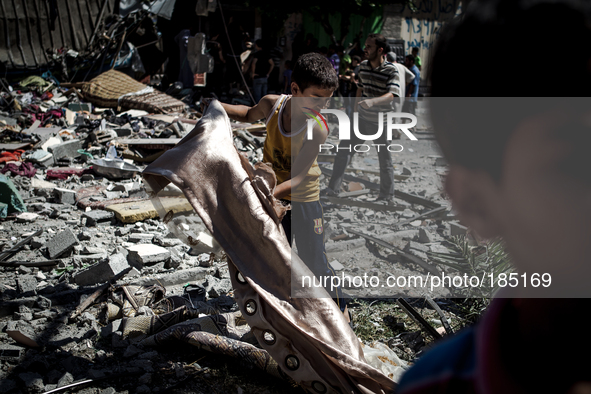 A young boy searches the remains of a home on Jaffa Street in Northern Gaza City for belongings minutes after the house was attacked by an I...