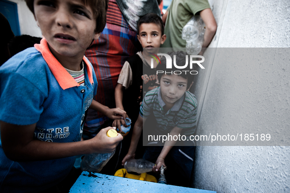 Children filling bottels with water at a make-shift refugee camp in Jabalya, Gaza on July 18th, 2014. The former school currently holds appr...