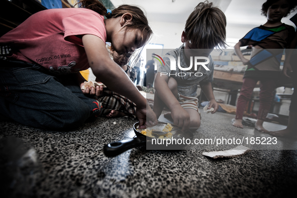 Children eating in a make-shift refugee camp in Jabalya, Gaza on July 18th, 2014. The former school currently holds approximately 3500 Pales...