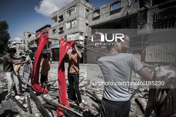 Young men searching the remains of a home on Jaffa Street in Northern Gaza City for belongings minutes after the house was attacked by an Is...