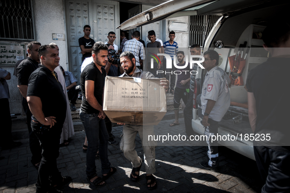 A man carries a box with bodyparts out of the Central Morgue in Gaza City on July 19th, 2014.