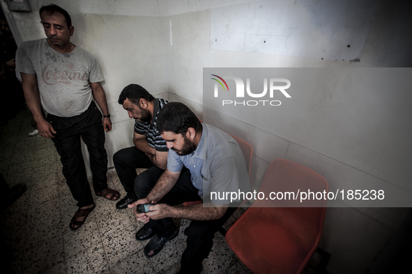 Relatives of two killed children waiting inside the Central Morgue in Gaza City to take the bodies to the graveyard on July 20th, 2014.