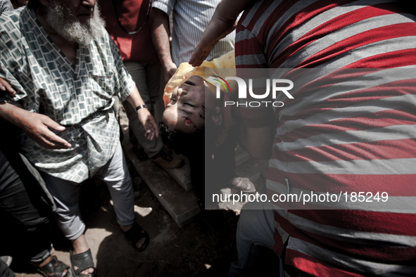 The dead body of a young boy (9 years) who was killed by a tank shell in Gaza City is being burried on a graveyard in Gaza City on July 20th...