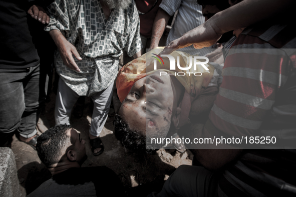 The dead body of a young boy (9 years) who was killed by a tank shell in Gaza City is being burried on a graveyard in Gaza City on July 20th...