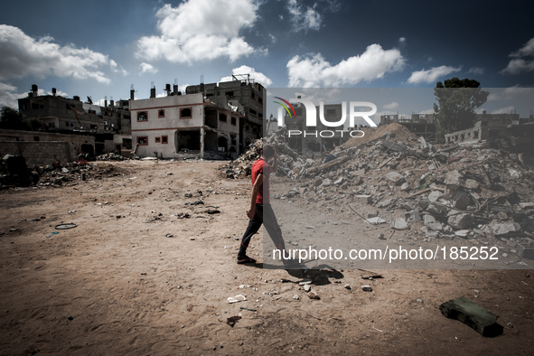 A young boy walks along ruins that in a residential area in Gaza City on July 20th, 2014.