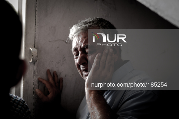 A man mourns about the death of two brothers (5 and 9 years) that have been killed by an Israeli tank shell in Gaza City on July 20th, 2014.