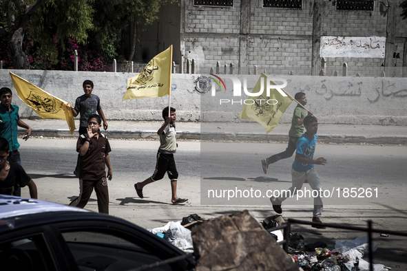 A group of young boys with Palestinian flags running towards a funeral in Gaza City on July 20th, 2014.