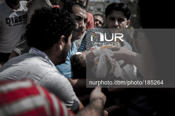 The dead body of a young boy (5 years) who was killed together with his brother (9 years) by a tank shell in Gaza City is being burried on a...