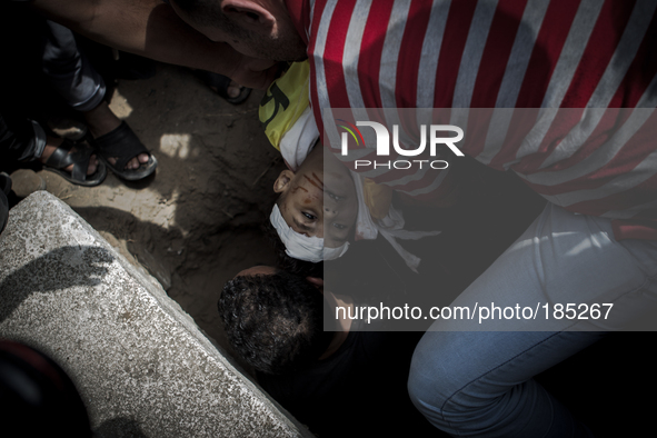 The dead body of a young boy (5 years) who was killed together with his brother (9 years) by a tank shell in Gaza City is being burried on a...