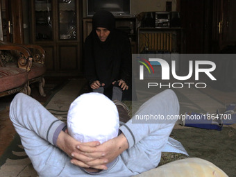 Syrian Umm Mohammed, performs rehabilitation exercises with her war injured husband at their home in the rebel-held town of Douma, on the ou...