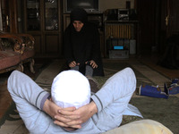 Syrian Umm Mohammed, performs rehabilitation exercises with her war injured husband at their home in the rebel-held town of Douma, on the ou...