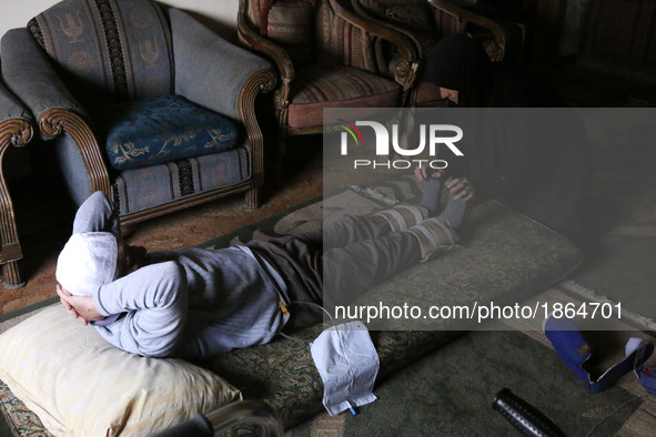 Syrian Umm Mohammed, performs rehabilitation exercises with her war injured husband at their home in the rebel-held town of Douma, on the ou...