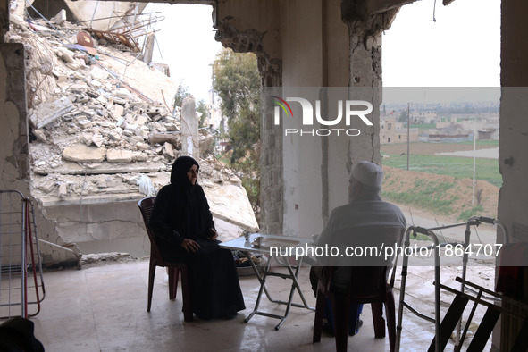 Syrian Umm Mohammed, and her husband drink coffee at their destroyed home in the rebel-held town of Douma, on the outskirts of the capital D...