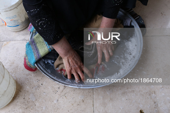 Syrian Umm Mohammed, washes laundry at her home in the rebel-held town of Douma, on the outskirts of the capital Damascus, on March 25, 2017...