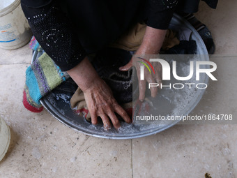 Syrian Umm Mohammed, washes laundry at her home in the rebel-held town of Douma, on the outskirts of the capital Damascus, on March 25, 2017...