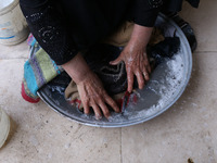 Syrian Umm Mohammed, washes laundry at her home in the rebel-held town of Douma, on the outskirts of the capital Damascus, on March 25, 2017...