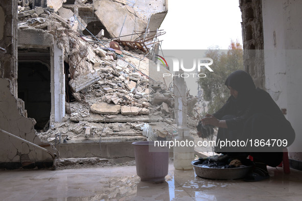 Syrian Umm Mohammed, washes laundry at her home in the rebel-held town of Douma, on the outskirts of the capital Damascus, on March 25, 2017...