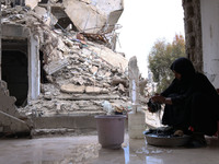 Syrian Umm Mohammed, washes laundry at her home in the rebel-held town of Douma, on the outskirts of the capital Damascus, on March 25, 2017...