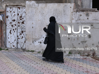 Syrian Umm Mohammed, arrives to a literacy school in the rebel-held town of Douma, on the outskirts of the capital Damascus, on March 25, 20...