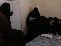 Syrian Umm Mohammed (2-R), attends a literacy class in the rebel-held town of Douma, on the outskirts of the capital Damascus, on March 25,...