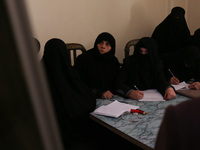 Syrian Umm Mohammed (2-R), attends a literacy class in the rebel-held town of Douma, on the outskirts of the capital Damascus, on March 25,...