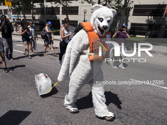 A person in a polar bear costume drags a block of ice during the March for Science in Los Angeles, California on April 22, 2017. The event w...