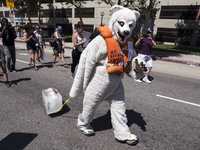 A person in a polar bear costume drags a block of ice during the March for Science in Los Angeles, California on April 22, 2017. The event w...
