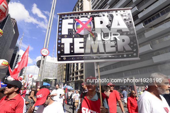 A demonstrator holds up a sign that reads 'Out Temer' during a workers union protest against President Michel Temer's government on Labor Da...