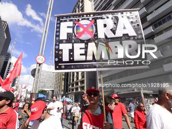 A demonstrator holds up a sign that reads 'Out Temer' during a workers union protest against President Michel Temer's government on Labor Da...