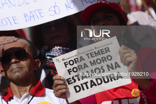 A demonstrator holds up a sign that reads 'Out Temer' during a workers union protest against President Michel Temer's government on Labor Da...