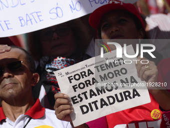 A demonstrator holds up a sign that reads 'Out Temer' during a workers union protest against President Michel Temer's government on Labor Da...