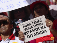 A demonstrator holds up a sign that reads 'Out Temer' during a workers union protest against President Michel Temer's government on Labor Da...