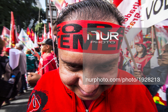 A demonstrator holds up a sign that reads 'Out Temer' during a workers union protest against President Michel Temer's government on Labor Da...