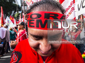 A demonstrator holds up a sign that reads 'Out Temer' during a workers union protest against President Michel Temer's government on Labor Da...