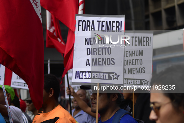 A demonstrator holds up a sign that reads 'Out Temer' during a workers union protest against President Michel Temer's government on Labor Da...